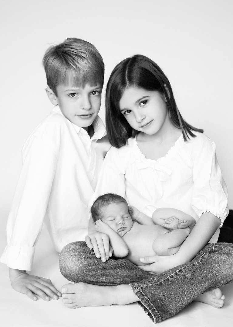black and white newborn portrait with siblings.